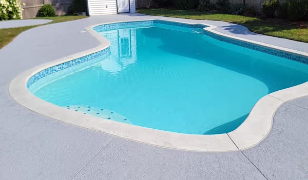 After: New polymer deck, new coping, new tile, pool filled