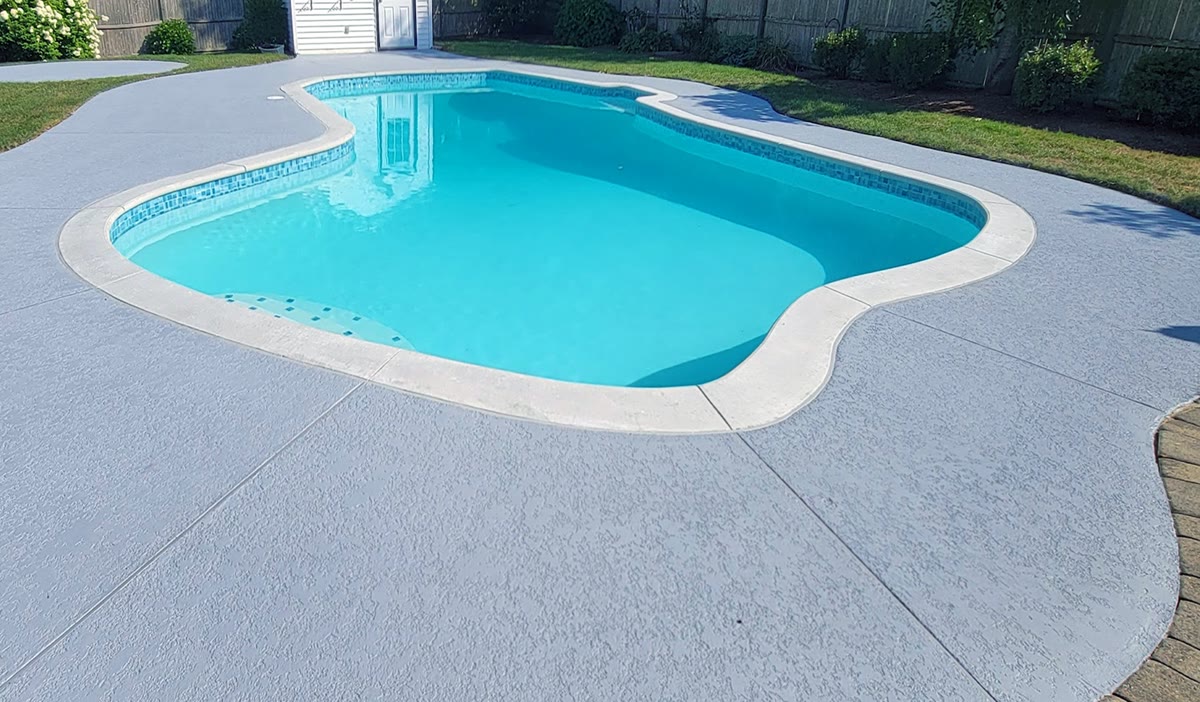 Completed swimming pool renovation with new plaster, tile, coping, and polymer concrete deck in Massachusetts